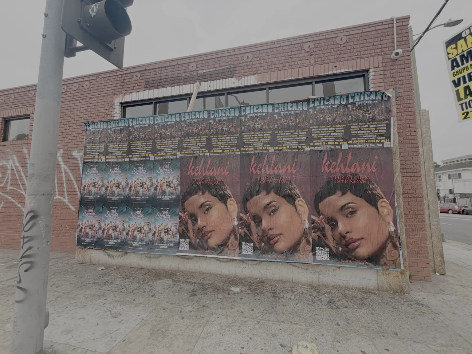 Large music posters installed on a brick building