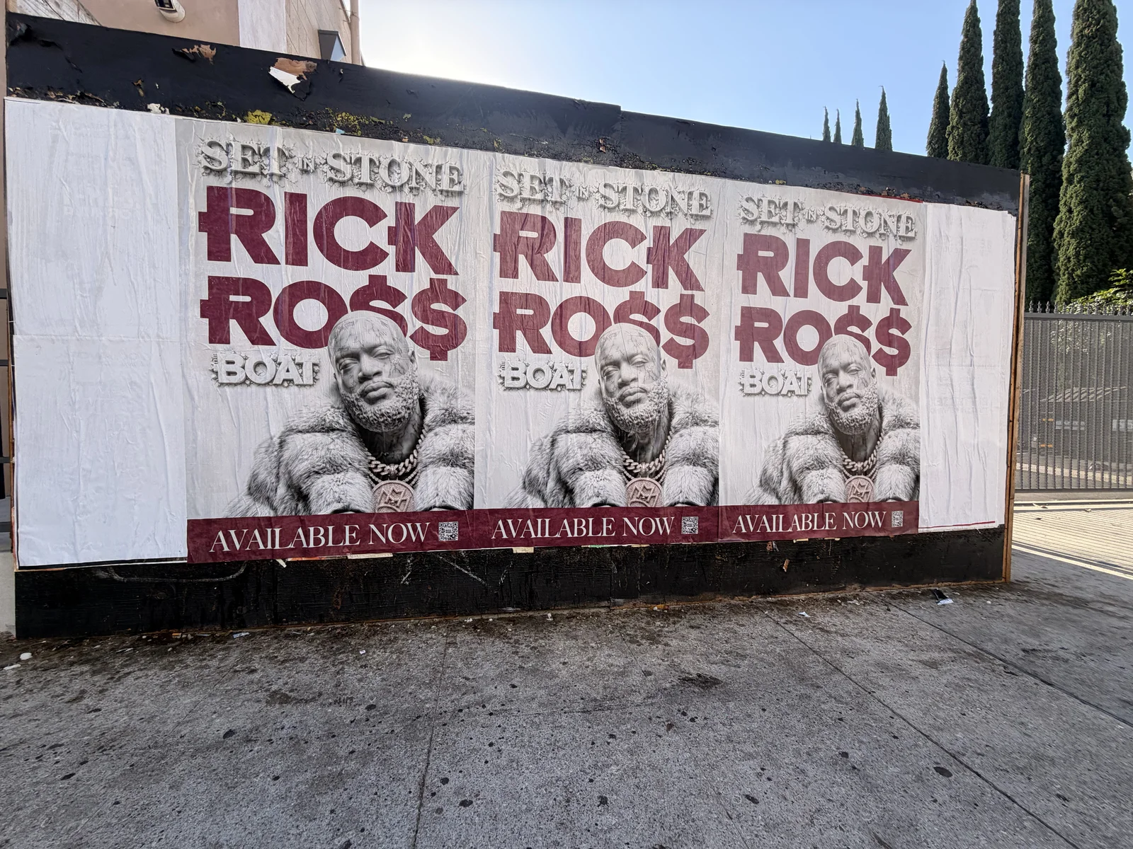 Three Rick Ross Set In Stone posters installed side by side on a street-facing wall